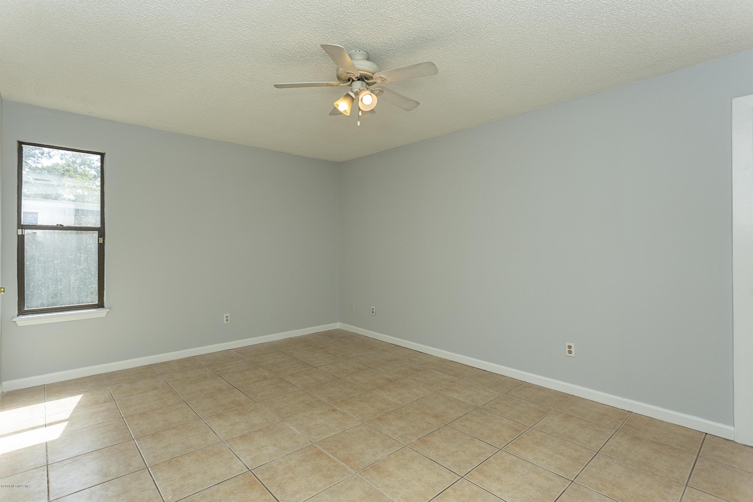 12782 Attrill Road Jacksonville, FL 32258 - Photo 13 of 25 an empty room with a chandelier fan and windows
