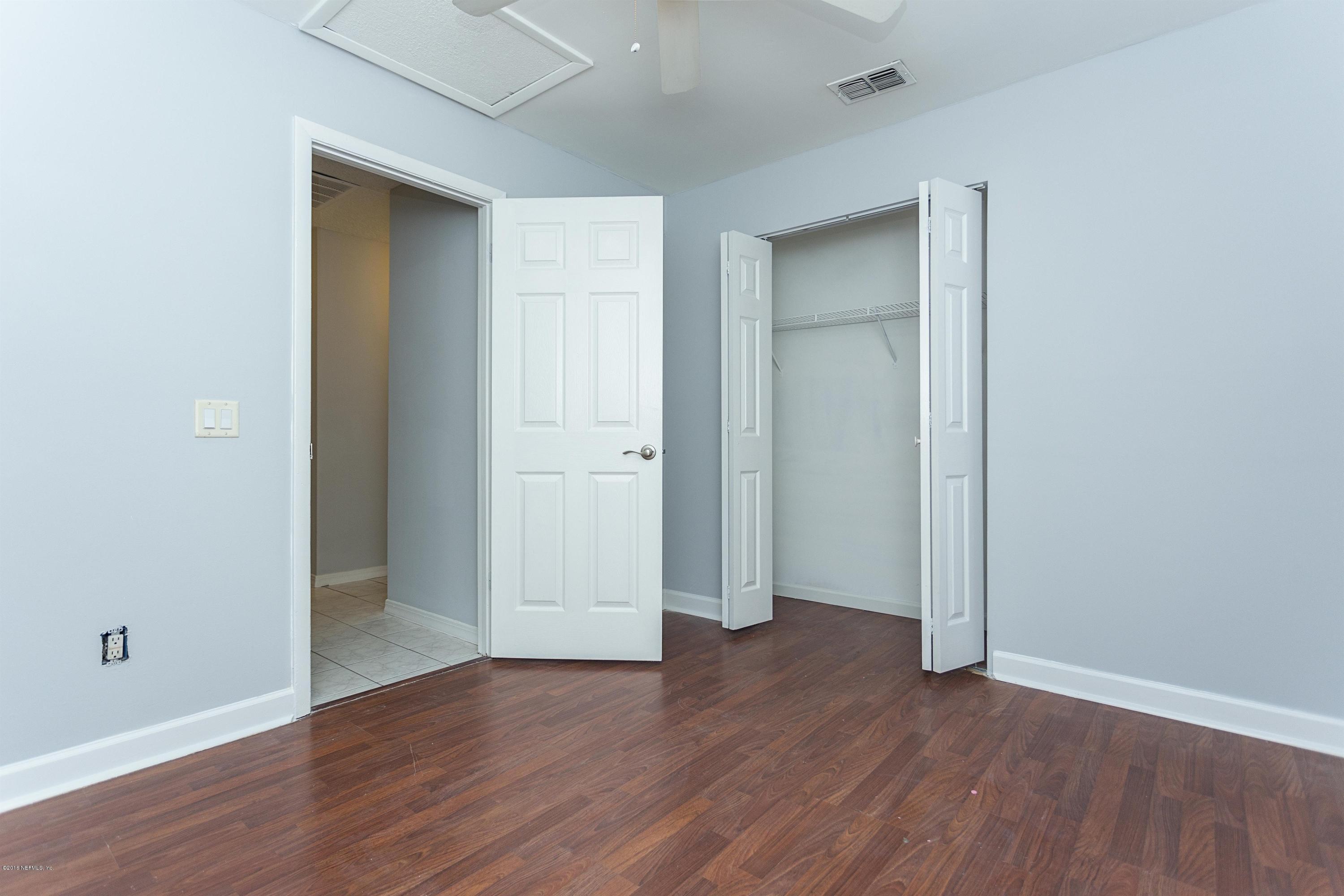 12782 Attrill Road Jacksonville, FL 32258 - Photo 17 of 25 an empty room with wooden floor and closet