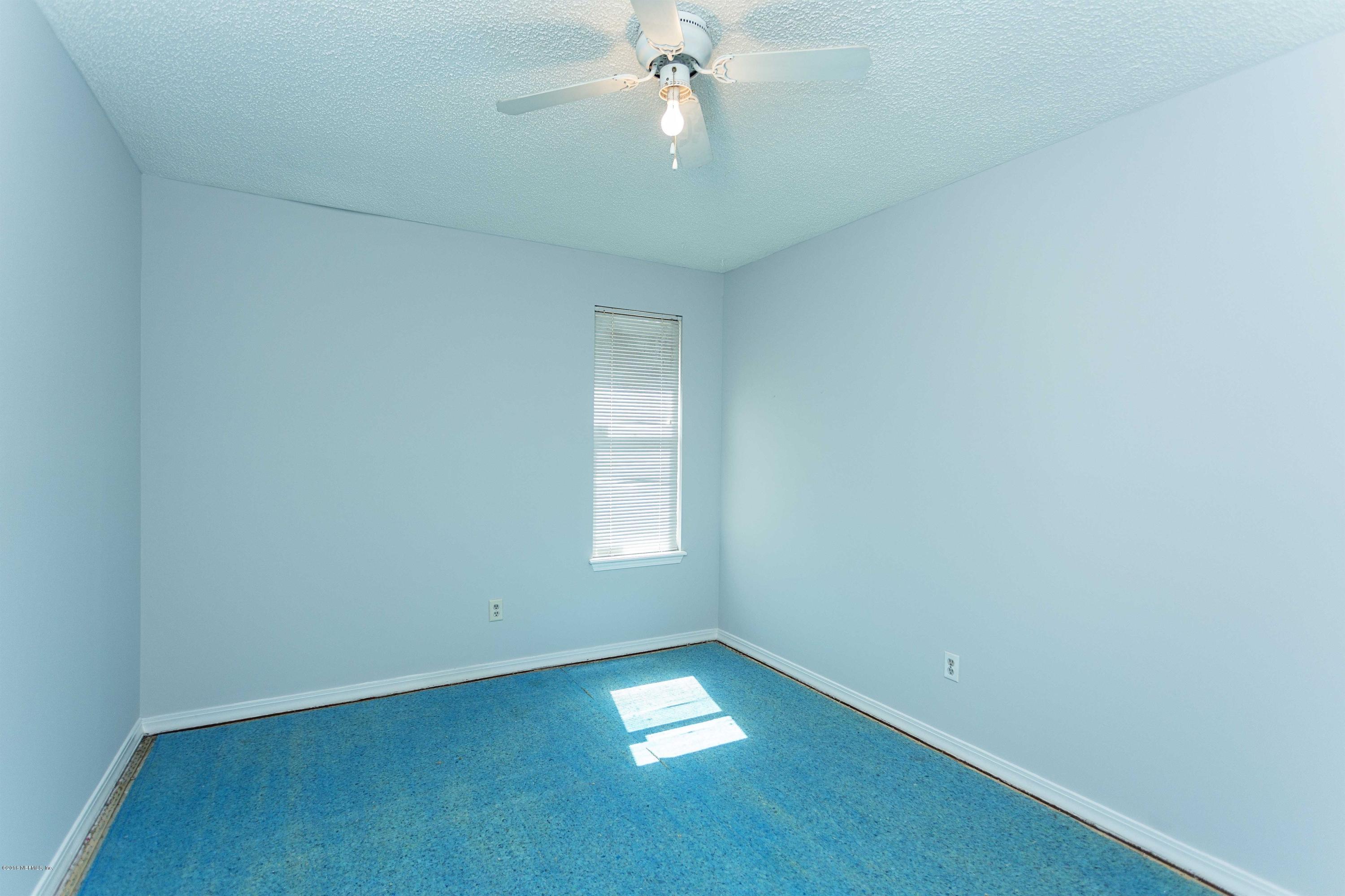 12782 Attrill Road Jacksonville, FL 32258 - Photo 19 of 25 an empty room with a chandelier fan and windows