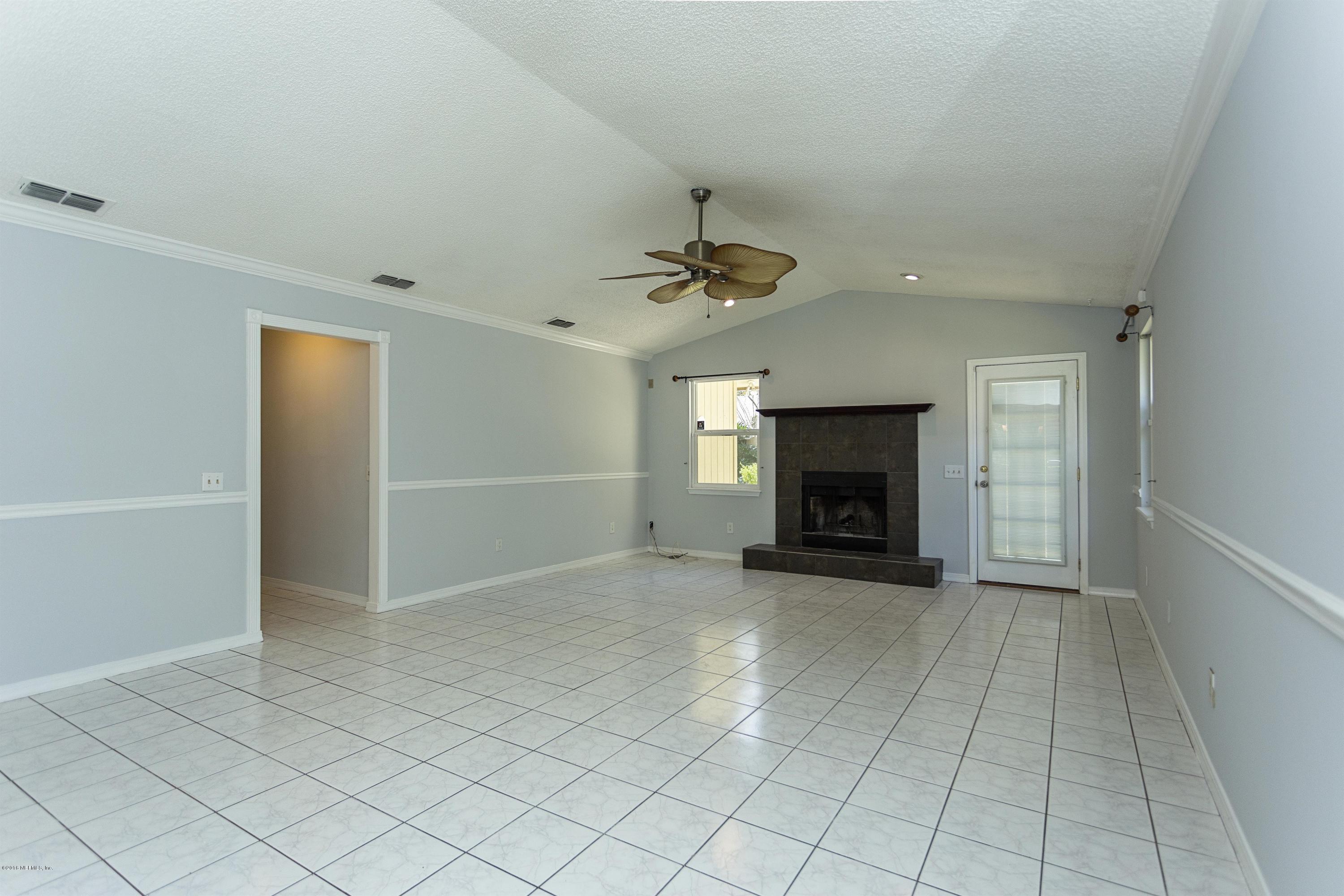 12782 Attrill Road Jacksonville, FL 32258 - Photo 5 of 25 an empty room with fireplace and fan