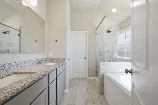 a bathroom with a granite countertop sink a mirror and a shower