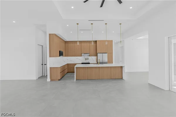 a large room with kitchen island a sink stainless steel appliances and cabinets