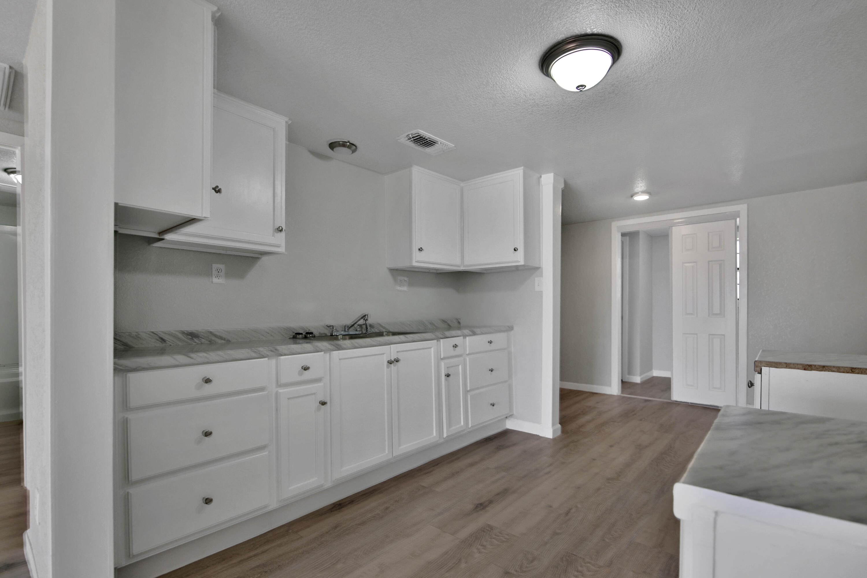 312 North Avenue R Lubbock, TX 79415 - Photo 7 of 26 a kitchen with granite countertop white cabinets and a sink