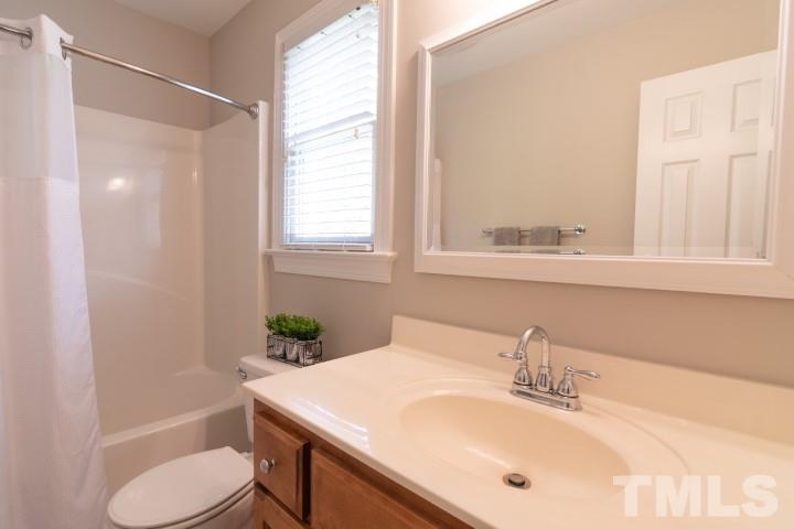 6940 Spring Drive Raleigh, NC 27613 - Photo 15 of 18 a bathroom with a sink toilet and shower