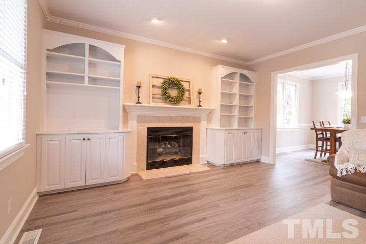 6940 Spring Drive Raleigh, NC 27613 - Photo 6 of 18 a view of a livingroom with wooden floor and a fireplace