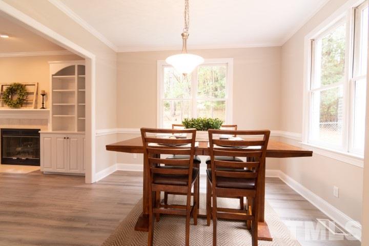 6940 Spring Drive Raleigh, NC 27613 - Photo 7 of 18 a view of a dining room with furniture window and wooden floor