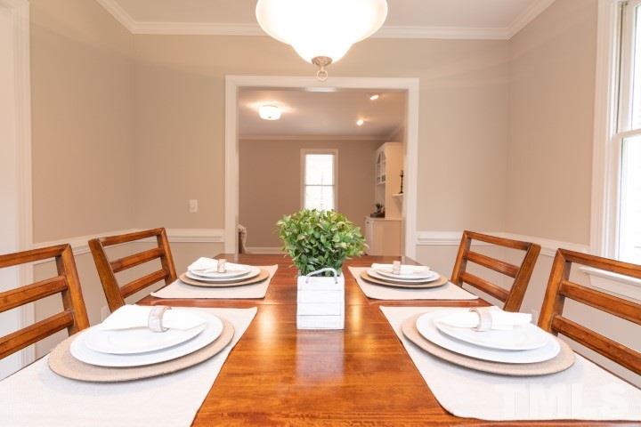 6940 Spring Drive Raleigh, NC 27613 - Photo 8 of 18 a view of a dining room with furniture and wooden floor