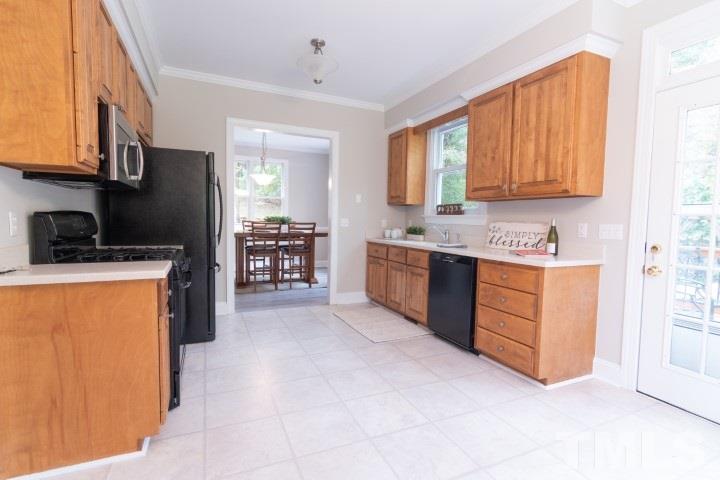 6940 Spring Drive Raleigh, NC 27613 - Photo 9 of 18 a kitchen with stainless steel appliances granite countertop a stove a sink and a refrigerator