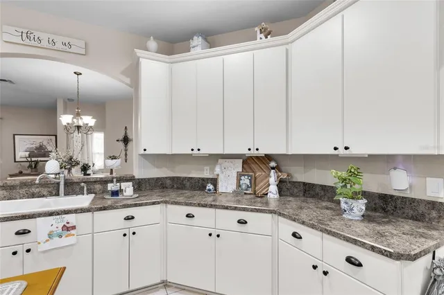 a kitchen with granite countertop white cabinets and white appliances