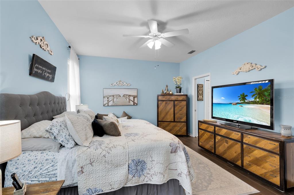 5138 Indian Ocean Loop Tavares, FL 32778 - Photo 24 of 35 a bedroom with a bed and a flat screen tv