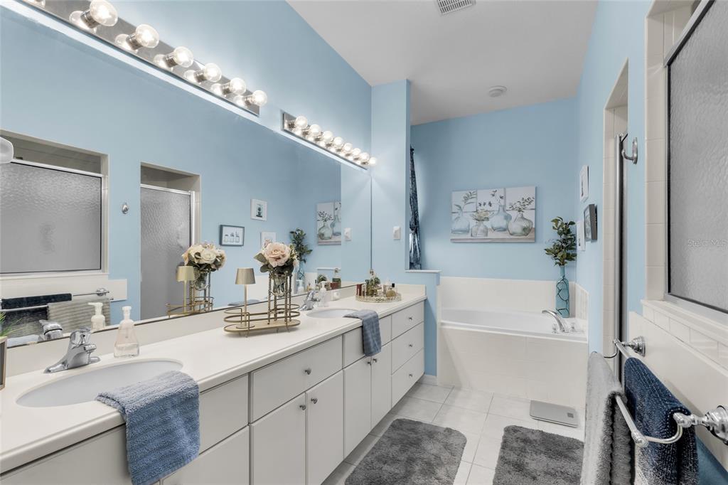 5138 Indian Ocean Loop Tavares, FL 32778 - Photo 26 of 35 a spacious en suite bathroom with a double vanity sink a mirror and a bathtub