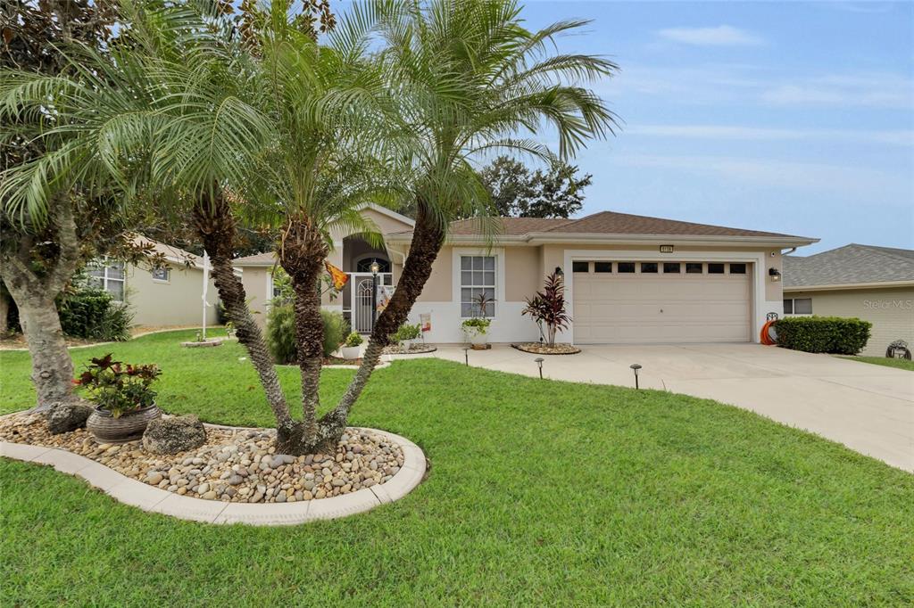 5138 Indian Ocean Loop Tavares, FL 32778 - Photo 9 of 35 a front view of a house with a garden and plants