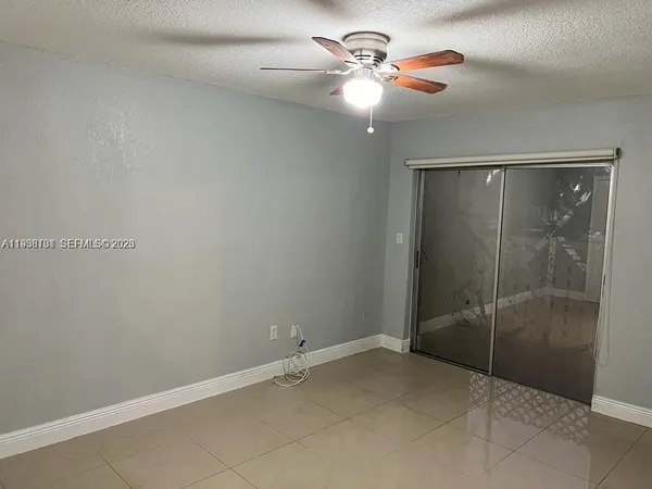 an empty room with closet and a chandelier fan