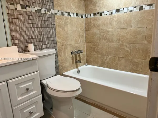 a bathroom with a granite countertop toilet a sink and bathtub