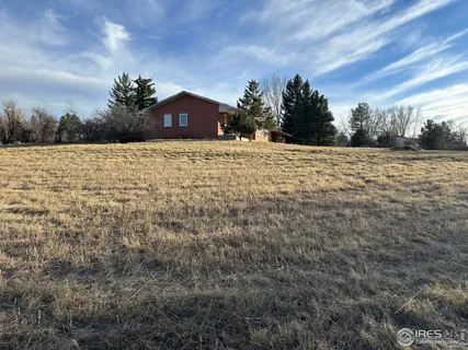 a view of a park with a barn and a street sign