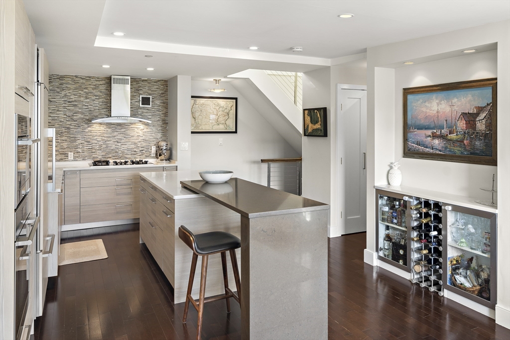 42 8th Street, Unit 5514 Boston, MA 02129 - Photo 7 of 38 a kitchen with stainless steel appliances kitchen island granite countertop a refrigerator and a stove top oven