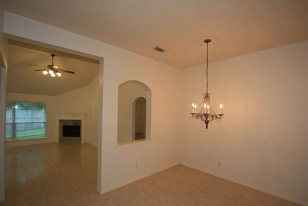 43 Steep Trail Place Conroe, TX 77385 - Photo 4 of 13 a view of an empty room with chandelier fan and fire place