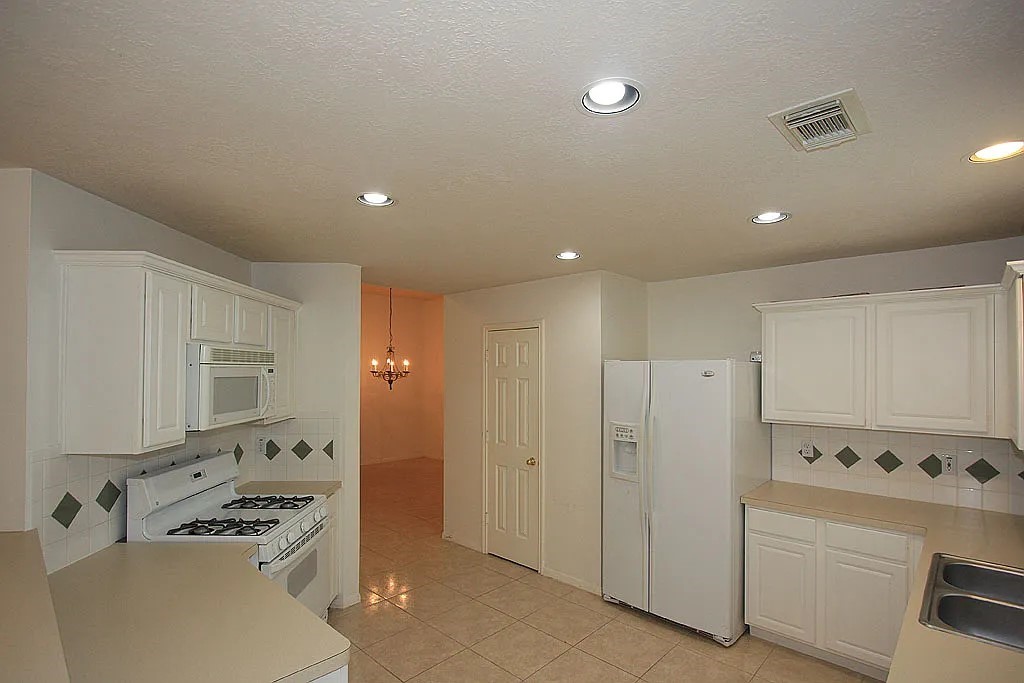 43 Steep Trail Place Conroe, TX 77385 - Photo 5 of 13 a kitchen with refrigerator cabinets and stove