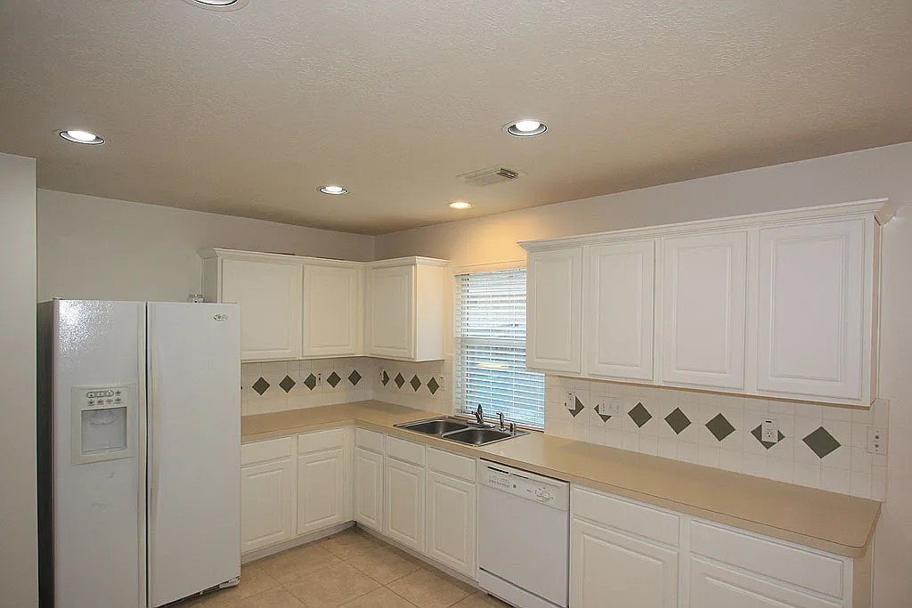 43 Steep Trail Place Conroe, TX 77385 - Photo 7 of 13 a kitchen with white cabinets and white appliances