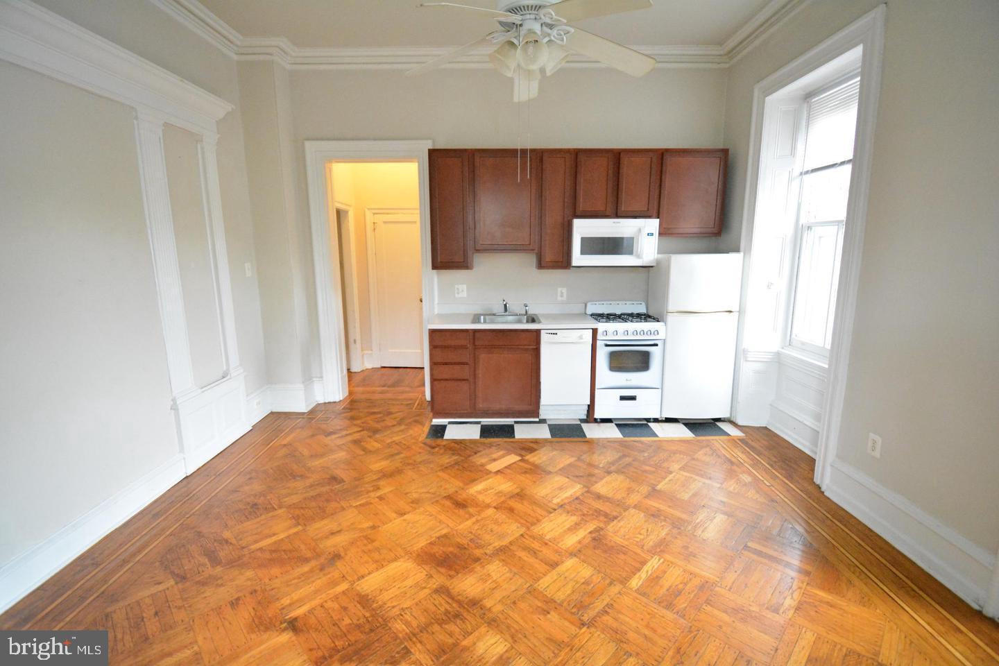 a large kitchen with a stove top oven a sink and a window