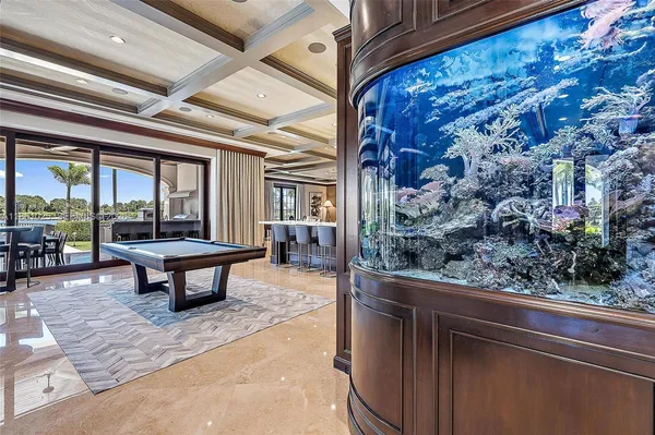 a large kitchen with stainless steel appliances wooden floor and a view of living room