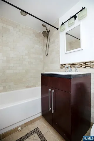 a bathroom with a granite countertop sink and a toilet