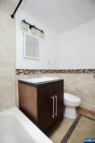 a hallway with wooden floor closet and livingroom