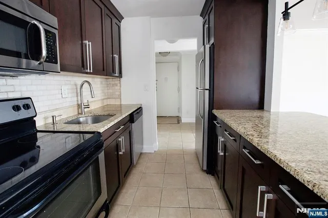 a kitchen with granite countertop stainless steel appliances and wooden cabinets