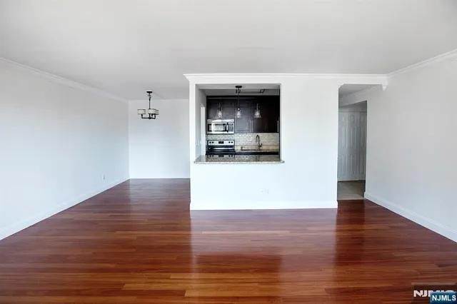 a view of a room with wooden floor and a ceiling fan