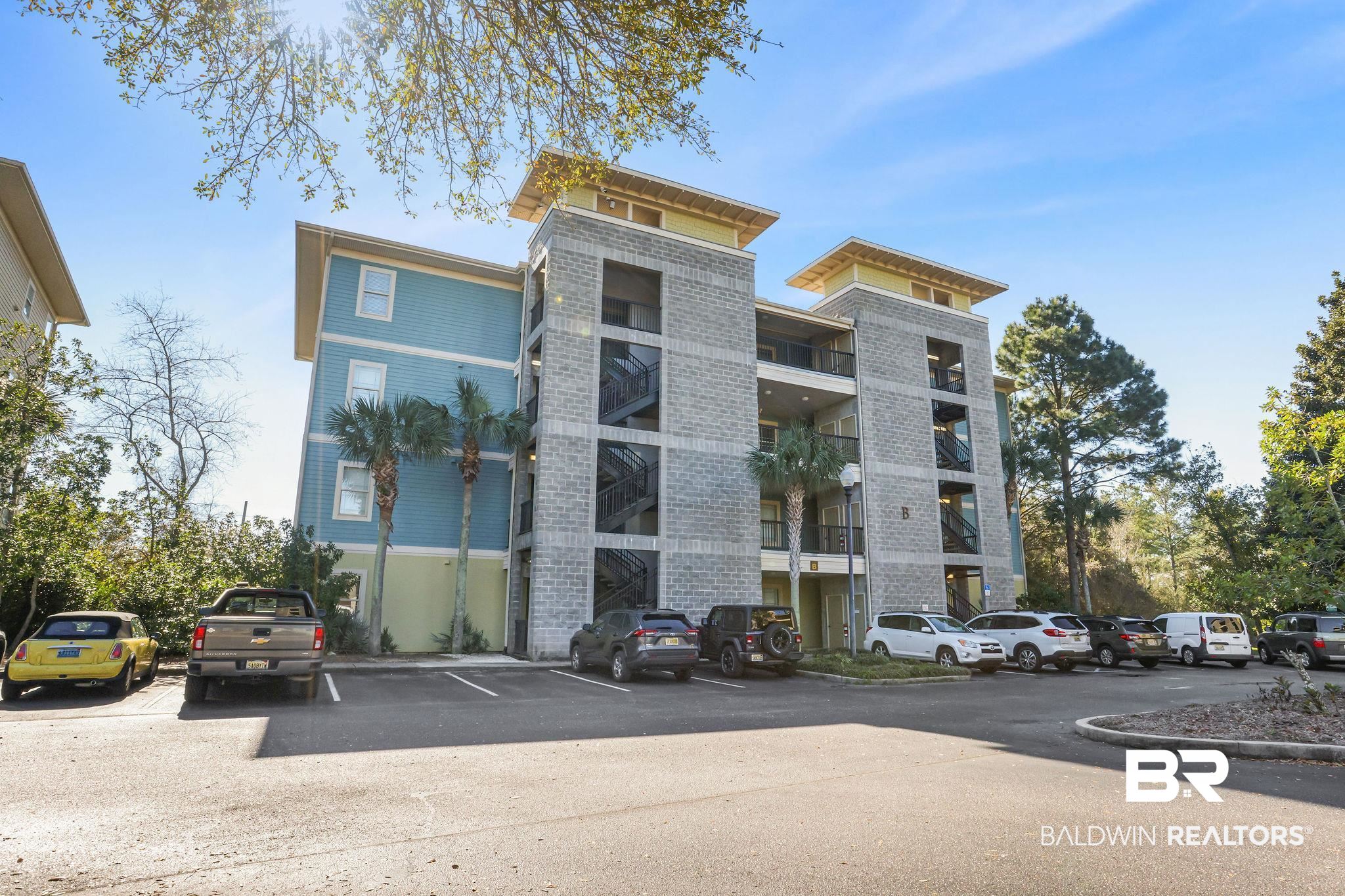 1430 Regency Road, Unit B302 Gulf Shores, AL 36542 - Photo 3 of 24 View of building exterior with uncovered parking