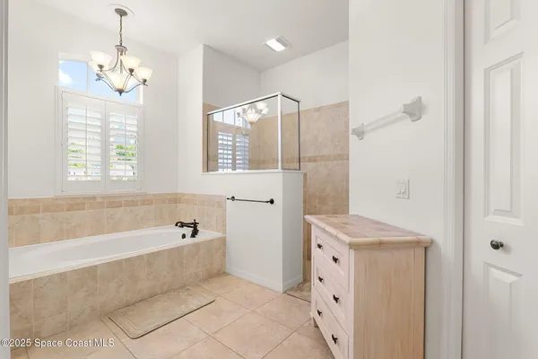 a bathroom with a tub a sink and a large mirror