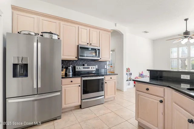 a kitchen with stainless steel appliances a refrigerator sink and microwave