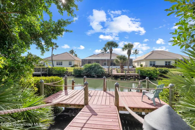 a view of a patio with chairs and a table with potted plants