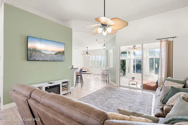 a living room with furniture a chandelier and a large window