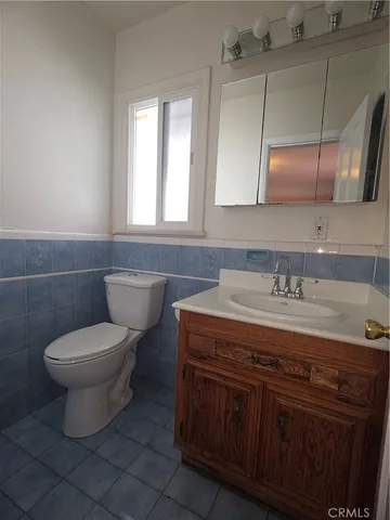 a bathroom with a granite countertop toilet a sink and a mirror
