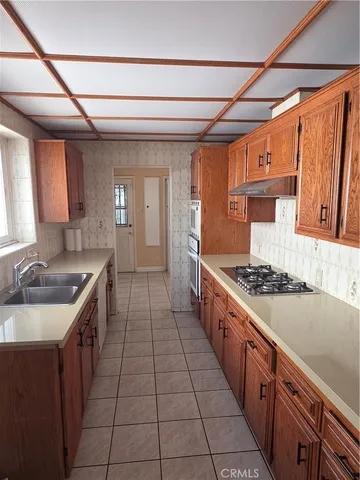 a kitchen with sink stove and cabinets