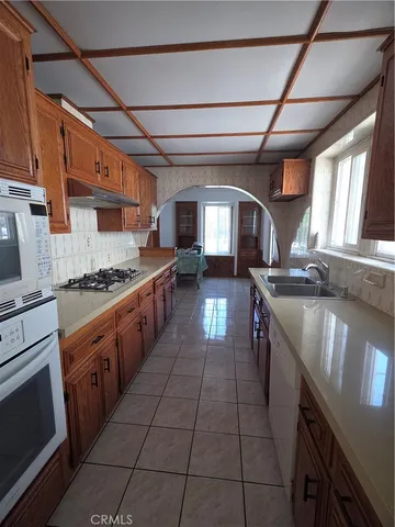 a large kitchen with stainless steel appliances granite countertop a stove a sink dishwasher and cabinets