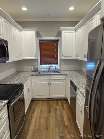 a kitchen with stainless steel appliances granite countertop a stove a sink and a refrigerator