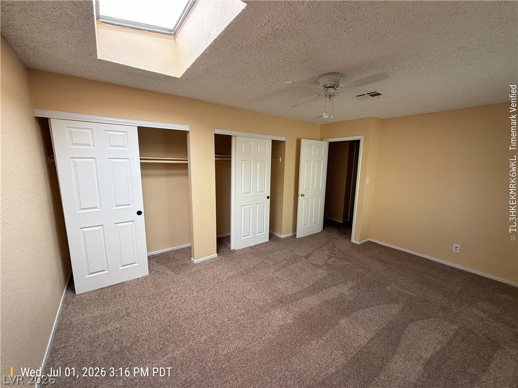 2313 Ragland Street Las Vegas, NV 89108 - Photo 6 of 11 Natural light from a ceiling skylight illuminates this generously sized bedroom with ample closet space.