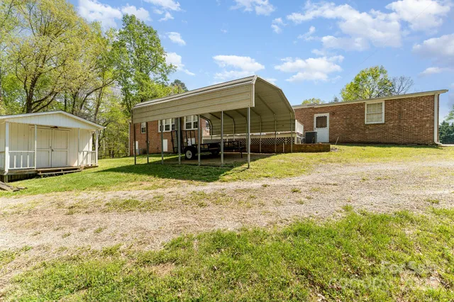 a view of a house with backyard and trees