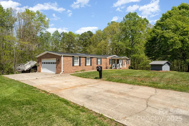 a front view of a house with a yard and trees