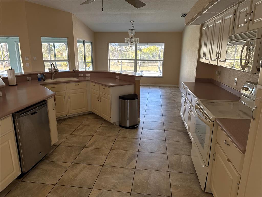 29310 Bryan Way Punta Gorda, FL 33982 - Photo 10 of 30 a kitchen with a sink a stove a microwave and a refrigerator