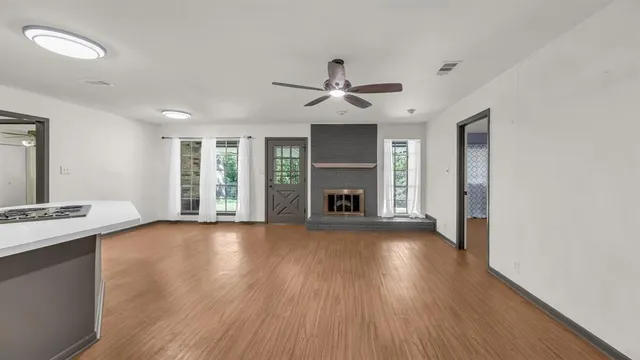 a view of empty room with wooden floor and fireplace