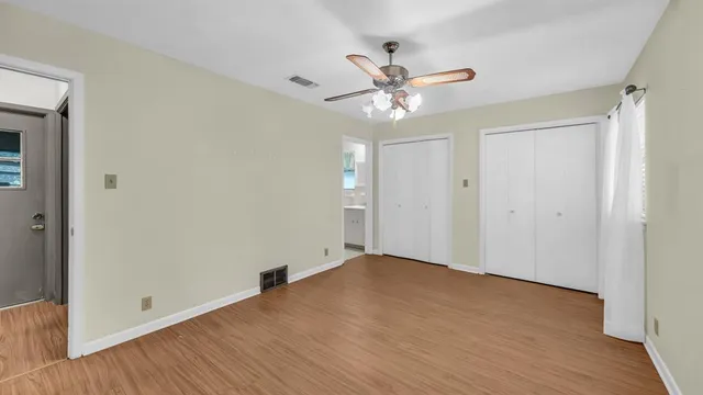 a view of an empty room with wooden floor