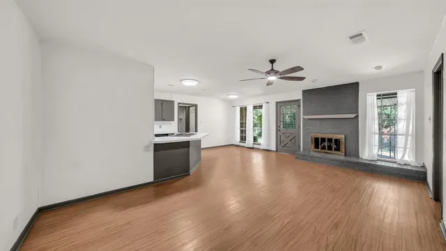 a view of an empty room with a fireplace and a window