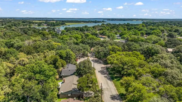 an aerial view of a house with a yard and lake view