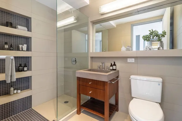 a bathroom with a toilet a sink and glass door