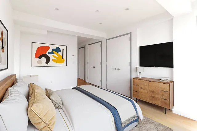 a bedroom with a bed and a flat screen tv