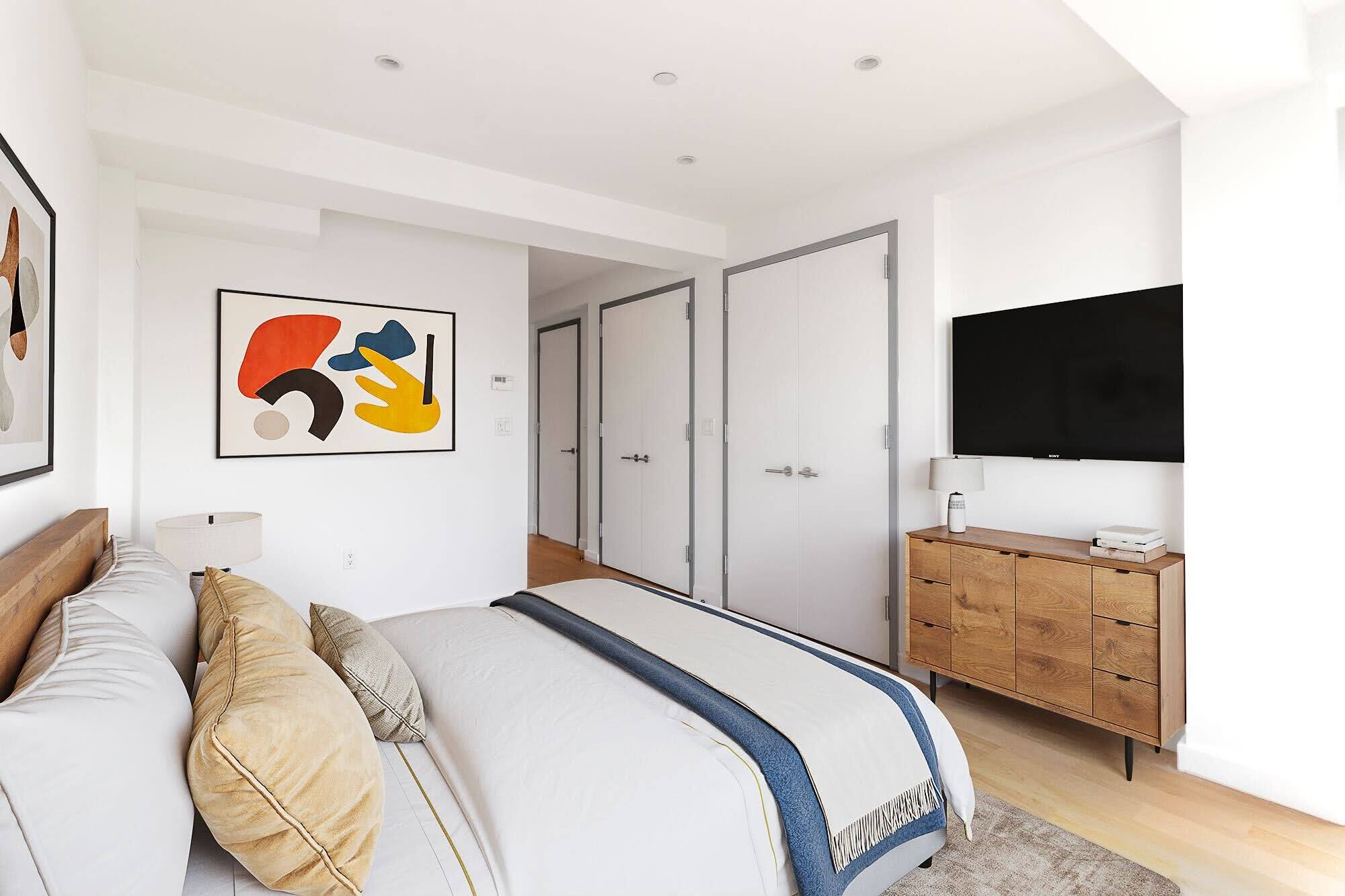 260 North 9th Street, Unit 7A Brooklyn, NY 11211 - Photo 5 of 7 a bedroom with a bed and a flat screen tv