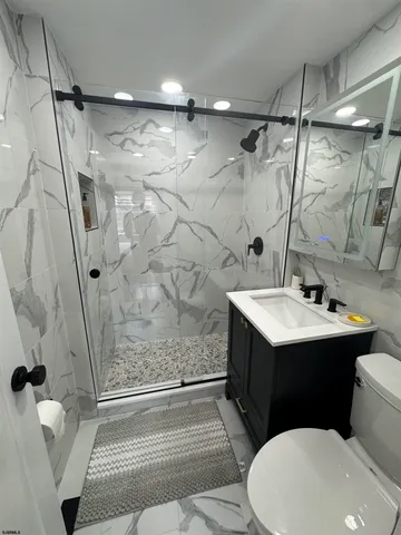 a bathroom with a sink a toilet and shower